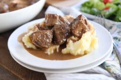 闷热的牛肉技巧和土豆泥在白色板材