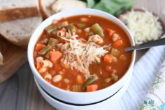 在两个被堆积的白色碗的Minestrone汤用巴马干酪